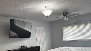 A bedroom with a bed, dresser, TV, ceiling fan, and window blinds. -  3-bedroom house in Arlington, 20 minutes from AT&T Stadium and the Stockyards. (Arlington)