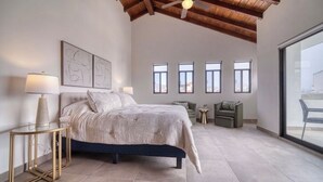 A bedroom with a bed, bedside lamps, a ceiling fan, a large window, and a view of the outside. - Casa Raquel 12 ppl, 5 BD, prime location, steps from Coral y Marina gated com (Ensenada)