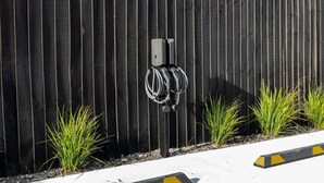 A black fence with a black and white cable reel mounted on it. - Beach Nearby | Balcony | Stroll to Town – KK77018 (Kaikōura)