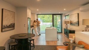 A modern interior with a dining area, kitchen, and a view to the outside. - Beach Nearby | Balcony | Stroll to Town – KK77018 (Kaikōura)