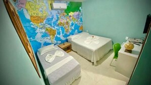 Une chambre avec deux lits, une carte accrochée au mur, une petite table et une chaise verte.