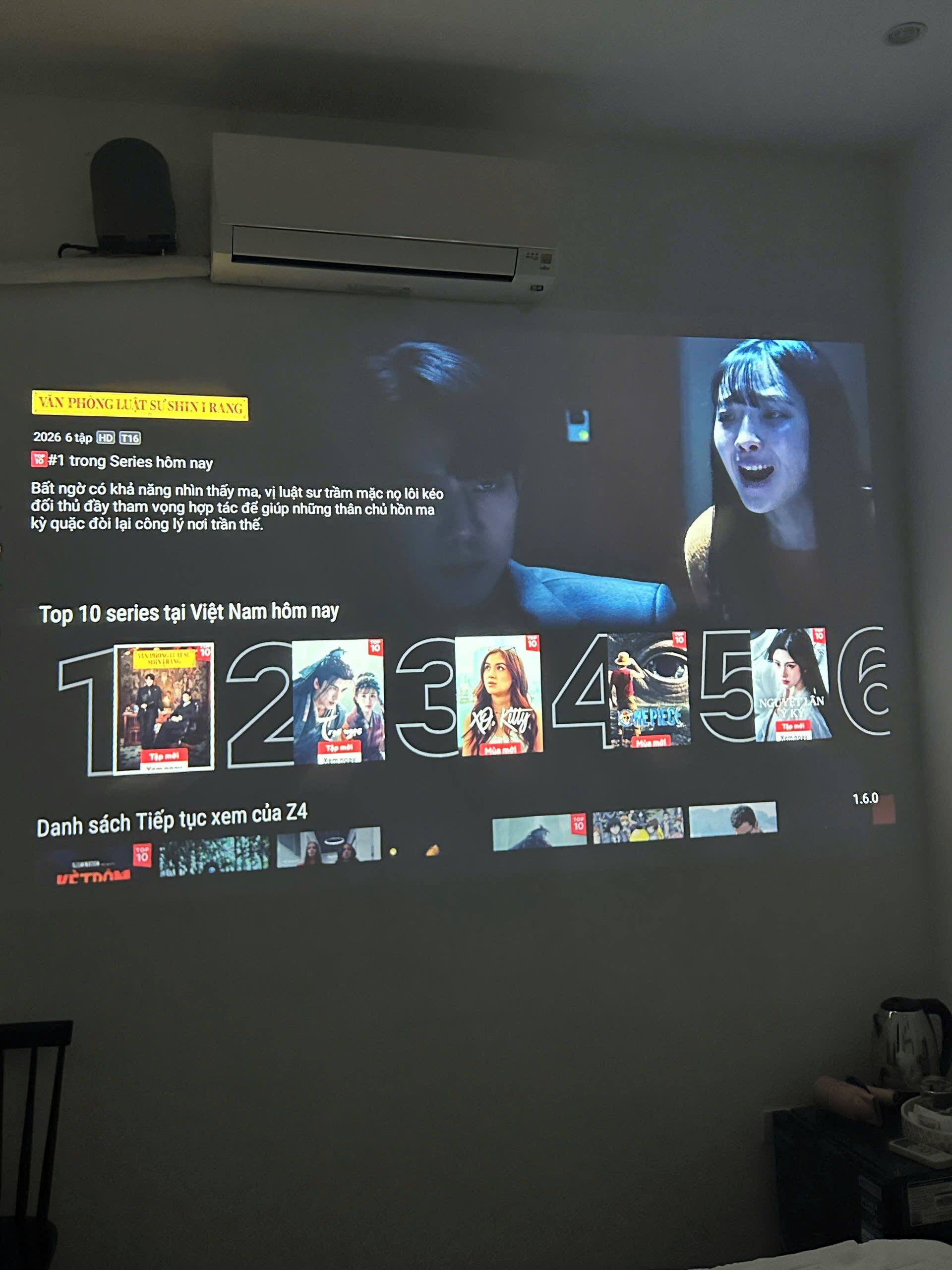 Una pantalla proyecta una lista de las diez series vietnamitas más populares, con un aire acondicionado visible en la parte superior.