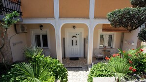 A courtyard with a stone pathway, a white door, and potted plants. - Lovely Apartment Vrsar 8 With Terrace, Vrsar, Croatia (Vrsar)