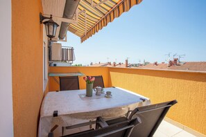 A balcony with a table, chairs, and a vase of flowers. - Lovely Apartment Vrsar 2 With Balcony, Vrsar, Croatia (Vrsar)