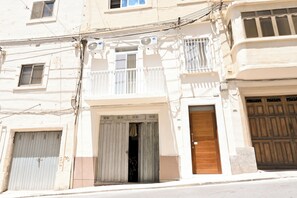 A multi-story building with balconies, a garage door, and a utility meter. - Walk to Balluta & Spinola - modern 2bdr apart, St Julian's, Malta (St Julian's)