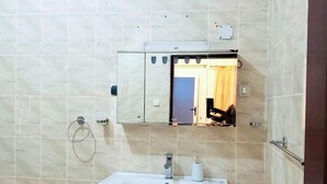 Ein Badezimmer mit Waschbecken, Spiegel und gefliesten Wänden.