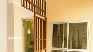 Ein Zimmer mit einem großen Fenster, einer Tür und einer Holzwand.