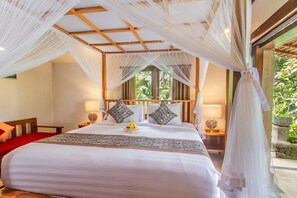 Une chambre à coucher avec un lit à baldaquin, une tête de lit en bois, des lampes de chevet et une vue sur la verdure.