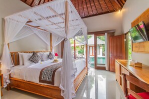 A four-poster bed with a canopy, a television on a wooden stand, and a view of a swimming pool.