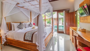 Un letto a baldacchino con tenda, un televisore su un supporto in legno e vista su una piscina.