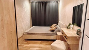 Un dormitorio con cama, mesita de noche, espejo y lámpara colgante.