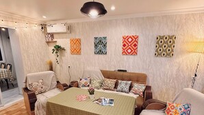Una sala de estar acogedora con un sofá, una mesita de centro y un tapete estampado.