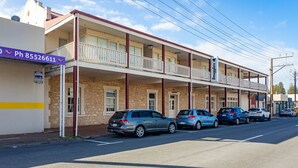 A two-story building with a balcony, a sign for 'Smugglers Inn', and several parked cars. - No 11 The Smugglers Inn (Victor Harbor)
