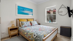 A bedroom with a bed, a nightstand, a window with a view, and a wall-mounted TV. - No 11 The Smugglers Inn (Victor Harbor)