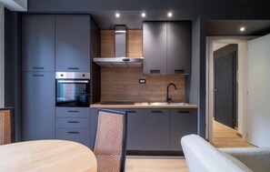 A modern kitchen with built-in appliances, a wooden countertop, and a dining area with a round table and chairs. - 2 bedroom lovely apartment in Santa Margherita (Santa Margherita)