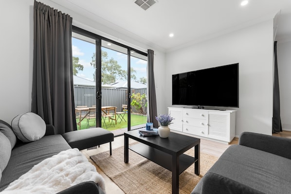 A modern living room with a sofa, coffee table, and TV.