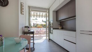 Una cucina compatta con zona pranzo, vista su un patio esterno e design moderno.