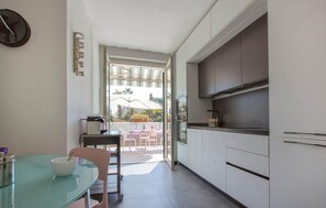 A compact kitchen with a dining area, a view to an outdoor patio, and a modern design. - Gorgeous apartment in Borgio Verezzi with WiFi (Borgio Verezzi)