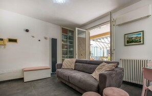 A living room with a grey sofa, a bench, and a radiator. - Gorgeous apartment in Borgio Verezzi with WiFi (Borgio Verezzi)