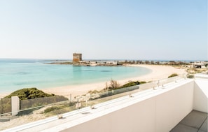 Blick auf die Küste mit einem Sandstrand, einer Turmkonstruktion und blauem Himmel.