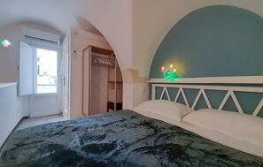 Ein Schlafzimmer mit Bett, Schrank und Fenster.