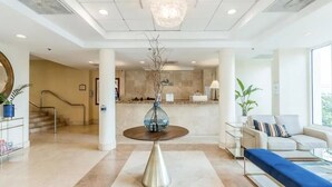 A spacious lobby with a round table, a staircase, and a seating area.