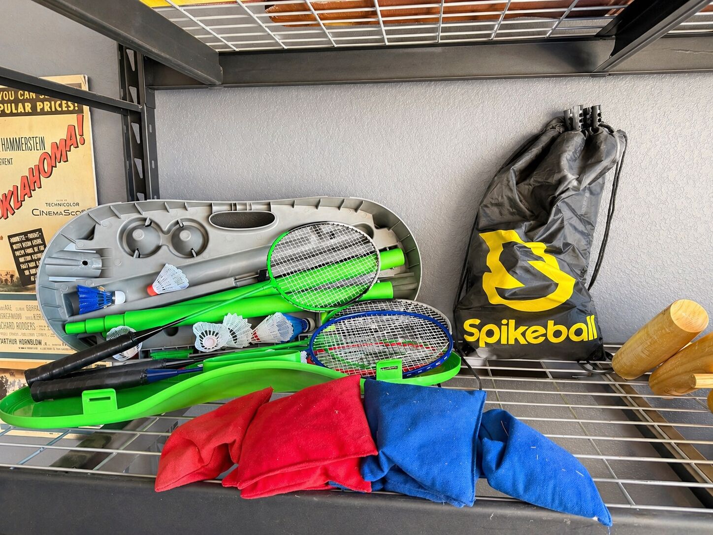 Un área de almacenamiento con raquetas de bádminton, volante y una bolsa con la etiqueta 'Spikeball'.