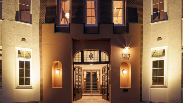 A building with a symmetrical facade, a central entrance with double doors, and two wall-mounted lights on either side. - T9 HAKODATE (Hakodate)