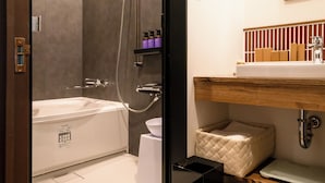 A modern bathroom with a bathtub, shower, and a vanity with a sink and storage. - T9 HAKODATE (Hakodate)