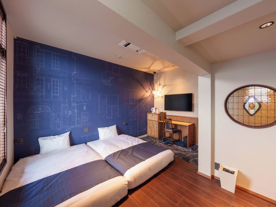 Una habitación de hotel con una cama grande, un escritorio, un televisor y un adorno en la pared.
