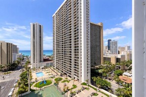 Un grand hôtel avec de nombreux étages, une piscine et une vue sur l’océan.