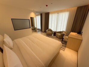 A hotel room with a large bed, a desk, a chair, and a television. - Swiss-Belhotel Nizwa (Nizwa)