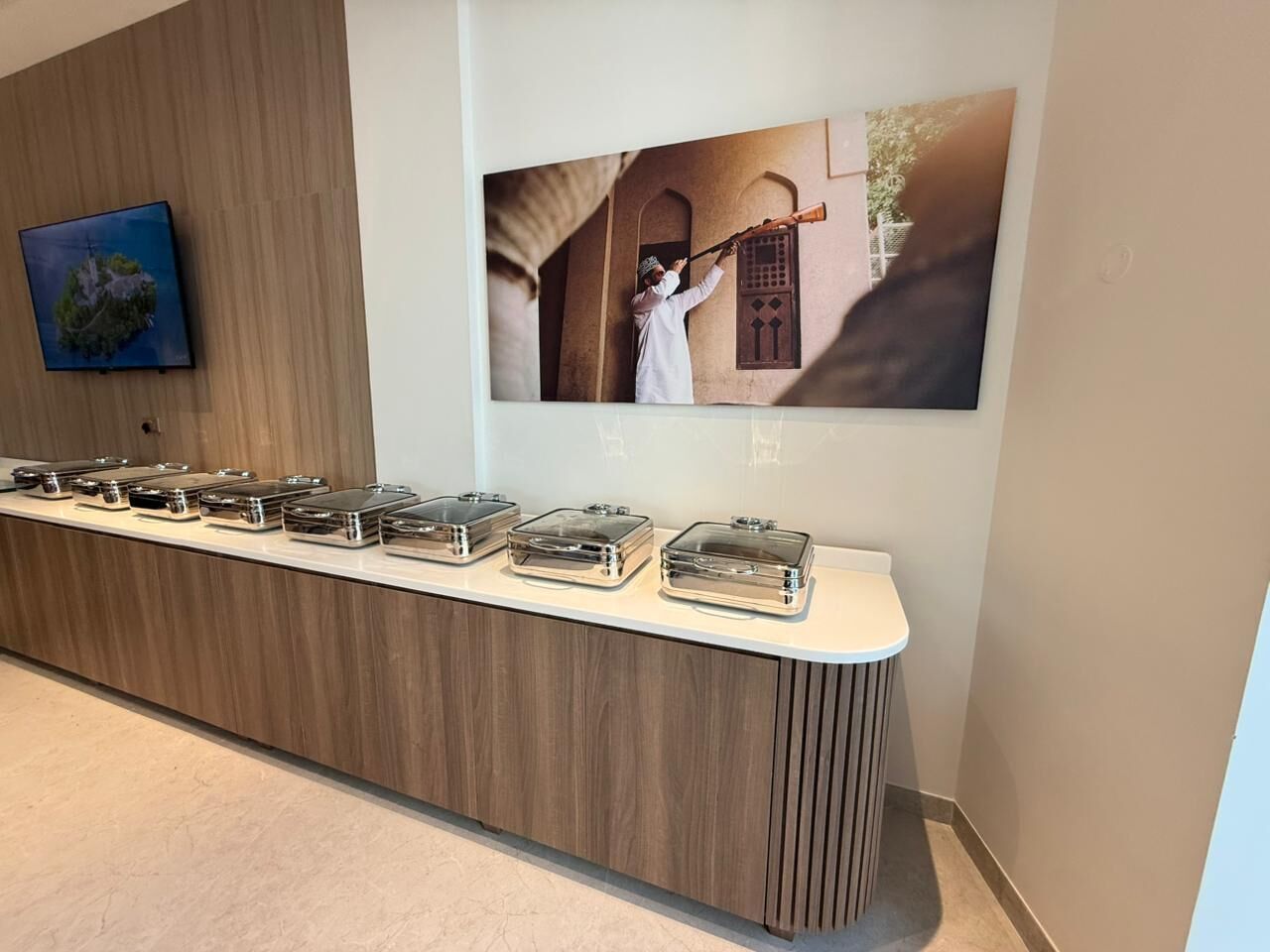 A reception area with a wooden counter, a wall-mounted television, and a framed photograph.