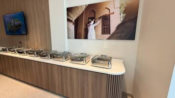 A reception area with a wooden counter, a wall-mounted television, and a framed photograph.