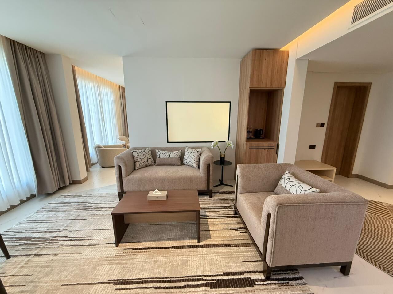 Ein modernes Wohnzimmer mit zwei Sofas, einem Couchtisch und einem Fernseher.