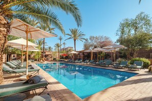 A swimming pool with lounge chairs and umbrellas, surrounded by palm trees and a clear sky. - Hotel Dar 55 Berbere House & Spa (Marrakech)