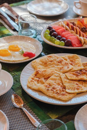 A breakfast setting with plates of food, including eggs, toast, and fruit. - Hotel Dar 55 Berbere House & Spa (Marrakech)