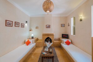Una sala de estar acogedora con chimenea, sofás blancos y un cartel de Netflix.