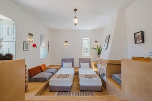A hotel room with two beds, a sofa, a small table, a plant, and a window. - Hotel Dar 55 Berbere House & Spa (Marrakech)