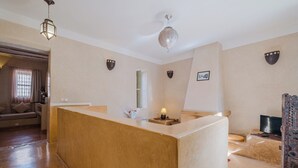 Un vestíbulo de hotel con una recepción, un sofá, una lámpara y apliques decorativos en la pared.