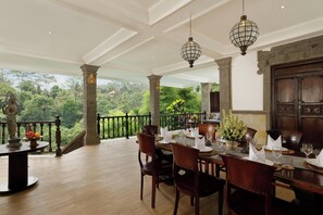 A dining area with a view of lush greenery, wooden furniture, and hanging lanterns. - 5 Bedroom Villa in Ubud with Jungle view (Ubud)