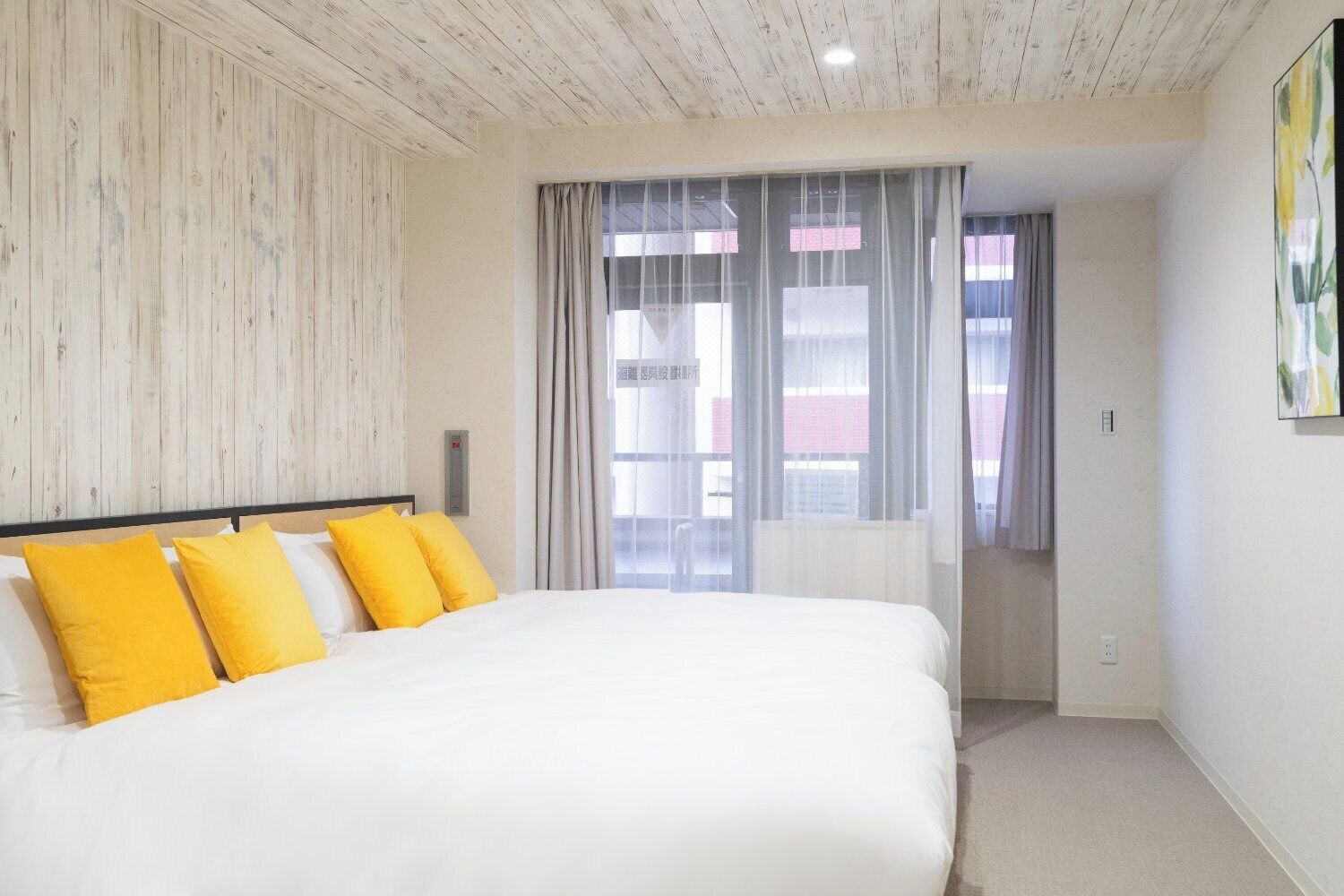 Ein Schlafzimmer mit Bett, einer Holzwand, einem Fenster mit Vorhängen und einer Heizung.
