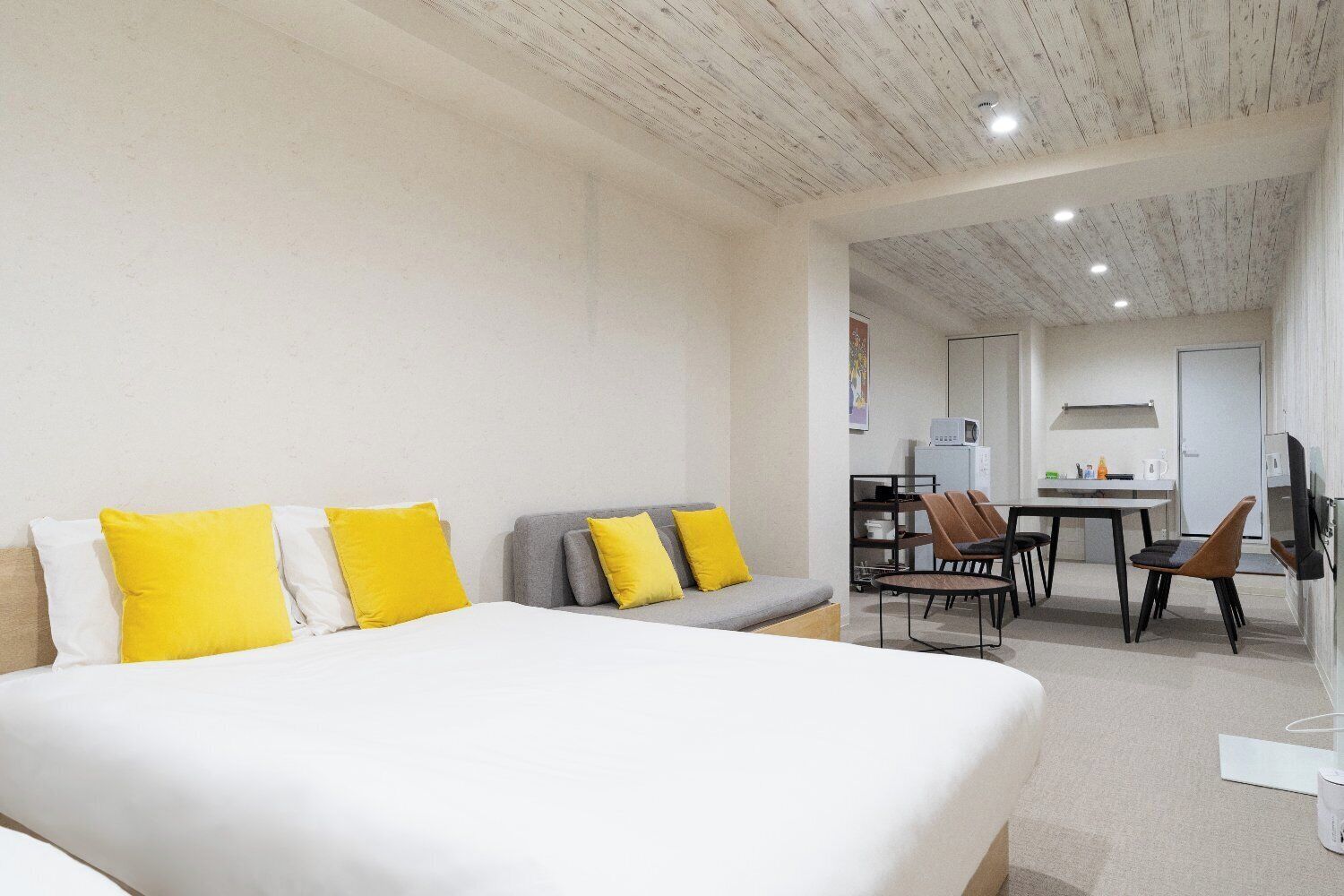 Une chambre d’hôtel dotée d’un grand lit, d’un canapé, d’un coin repas et d’une kitchenette.
