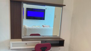 Un espace de travail comprenant un bureau, une chaise et un téléviseur fixé au mur.
