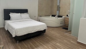 Une chambre à coucher avec un lit, une baignoire et une douche.