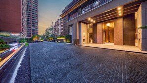 Um edifício moderno com entrada pavimentada, janelas amplas e fachada bem iluminada.