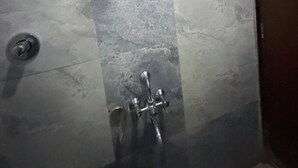 A bathroom with a shower, a toilet, and a sink. - Hotel SR Executive Akola (Akola)