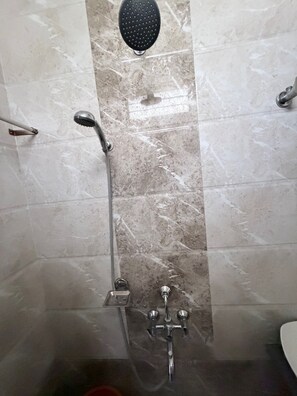 Een badkamer met een douche, douchekop en wandmengkraan.