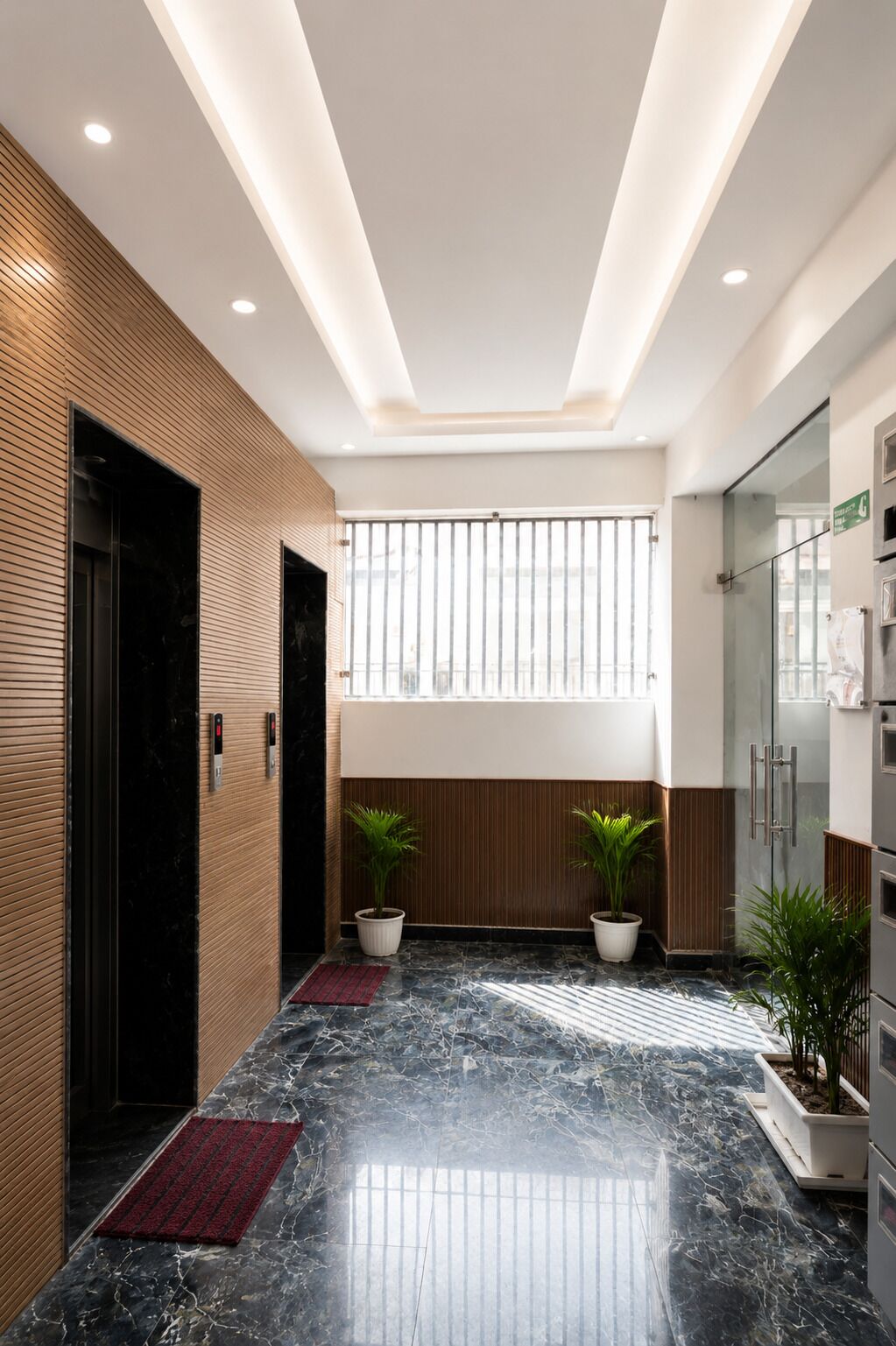 A modern lobby with a marble floor, wooden paneling, potted plants, and a glass elevator.