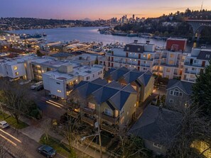An aerial view of a residential area with modern houses, a marina, and a city skyline in the background. - 3 Bed, 2.5 Bath Fremont Escape: Hot Tub, BBQ (Seattle)